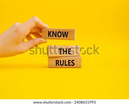 Know the rules symbol. Wooden blocks with words Know the rules. Beautiful yellow background. Businessman hand. Business and Know the rules concept. Copy space.
