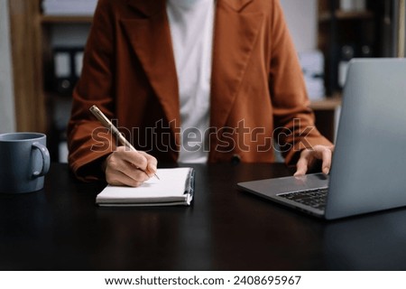 businesswoman hand working with new modern computer and writing on the notepad strategy diagram as concept morning light
