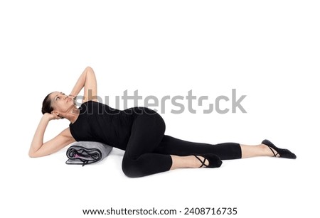 spine rotation variation pose, in the studio isolated on white. Specialized trauma releasing exercises for elderly people, 55 years old woman trainer posing for exercises. Royalty-Free Stock Photo #2408716735