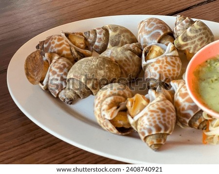 a photography of a plate of snails and a bowl of soup.