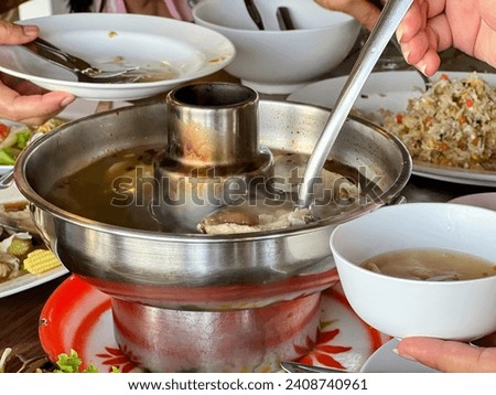 a photography of a table with a bowl of soup and plates of food.