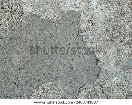 a photography of a concrete surface with a small patch of dirt.