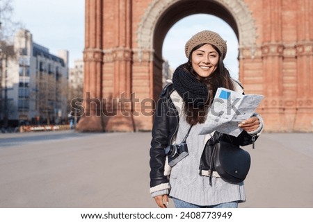Woman tourist sightseeing Barcelona holding city map in winter vacations