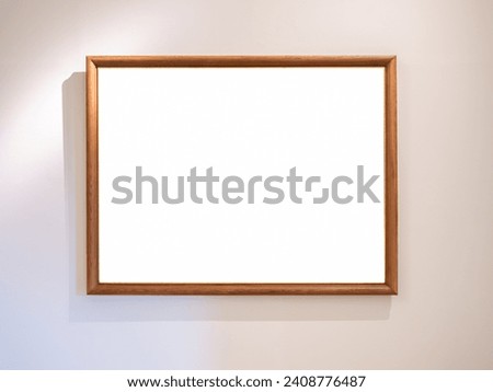 Mockup white blank space in thin wooden square picture frame, horizontal style, isolated. Empty single vintage brown rectangular simple photo frame hanging on white wall background with warm light.