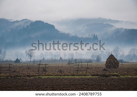 view of a fogy morning, hills and hay in maramures, romania, landscape image