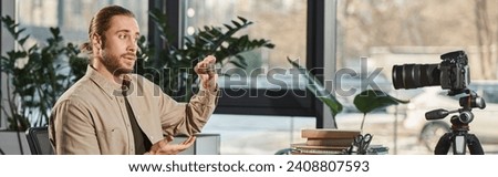 creative businessman holding bitcoins in front of digital camera during video blog in office, banner