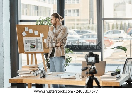 thoughtful businessman looking at flip charts with infographics near digital camera in office