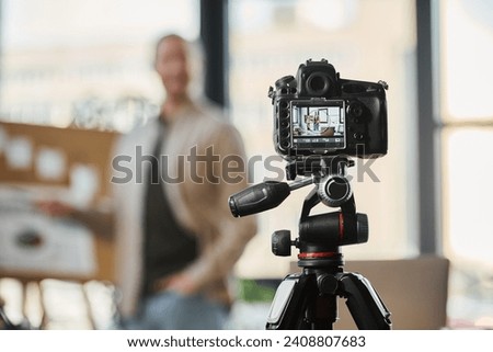 selective focus on digital camera near blurred businessman recording video blog in modern office