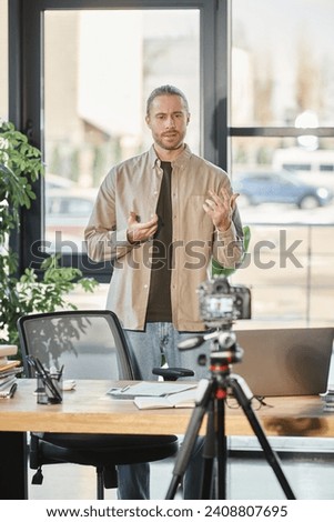creative businessman talking in front of digital camera during video blog in office, marketing