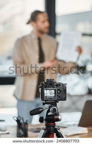 selective focus of modern digital camera near blurred businessman recording video blog in office