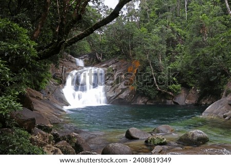 Long exposure shot of Josephine Falls in Queensland, Australia, surrounded by green trees in the middle of the jungle