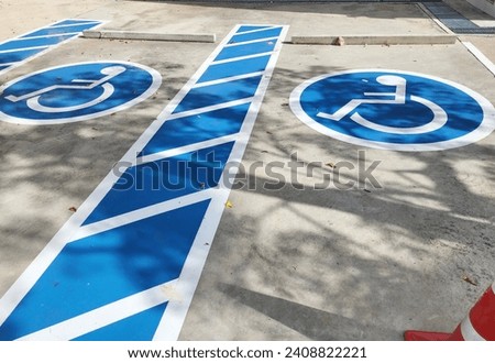 Blue rectangle handicapped sign with wheelchair and orange traffic cone. Handicapped symbol white on blue square frame and speed bump on a concrete road. To create convenience. Parking for wheelchair 