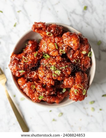 Korean fried chicken with samyang sauce is very delicious to eat with family or close friends with a slightly sweet and spicy taste with sesame seeds and a sprinkling of green onions  Royalty-Free Stock Photo #2408824853