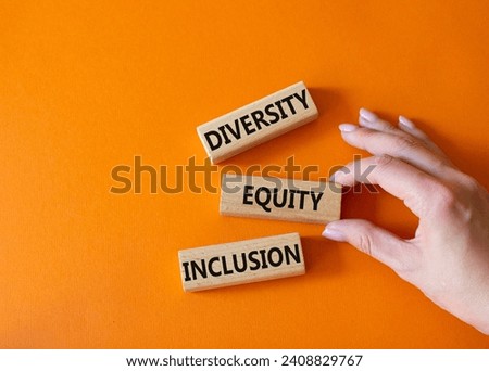 Diversity Equity Inclusion symbol. Concept words Diversity Equity Inclusion on wooden blocks. Beautiful orange background. Businessman hand. Business and Diversity Equity Inclusion concept. Copy space