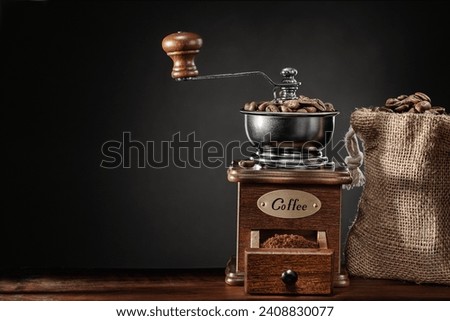 Classic Vintage Coffee Mill And Jute Bag With Beans On Dark Background Royalty-Free Stock Photo #2408830077