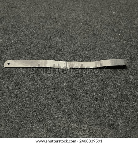 This is a photo of an iron ruler that has been bent due to frequent use