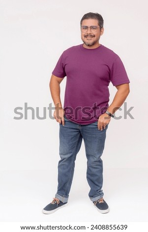 A stocky middle aged man wearing glasses.. Full body photo, wearing purple waffle shirt and jeans, isolated on a white background. Royalty-Free Stock Photo #2408855639