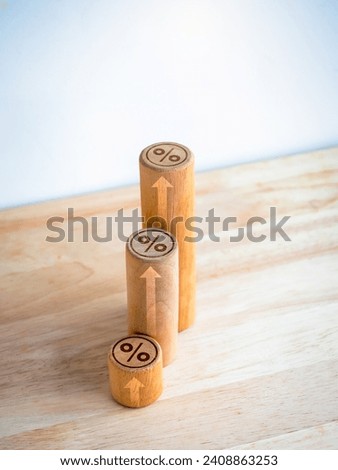 Percentage icon on top of wooden block bar graph step with rise up arrows on wood table and white background, vertical style, business growth process, profit, investment, economic improvement concept.