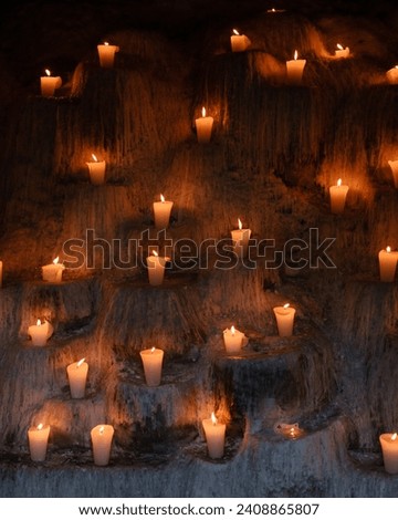 Candle lights in a nicely craved wall underneath a cemetery in Xcaret, Mexico