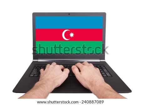 Hands working on laptop showing on the screen the flag of Azerbaijan