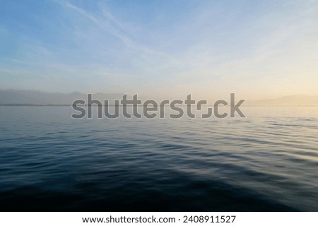 the tranquil transparent waters of lake Constance (Bodensee) with the Swiss Alps in the background on a calm October day on Lindau island, Germany                                Royalty-Free Stock Photo #2408911527