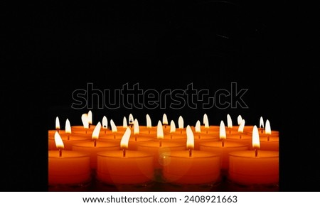 Close-up of a woman's hands lighting a candle in the dark with a match; the candle burns for a time before being extinguished by a gust of wind.