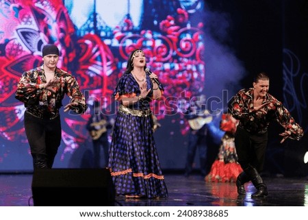 A collective of musicians, singers and dancers in gypsy costumes perform on stage.	 Royalty-Free Stock Photo #2408938685
