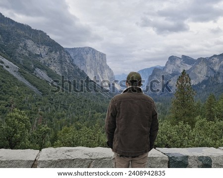 A man looking at the tunnel view, a man looking at a stunning green mountain view