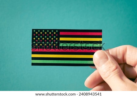 Juneteenth Freedom Day banner. African - American Independence day. A woman's hand holds an American flag on a turquoise, black history month concept.