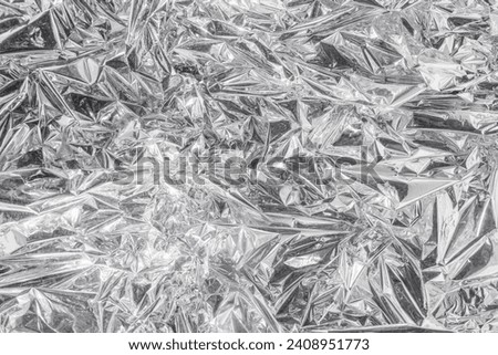 Abstract background image: crumpled foil reflecting rays of light