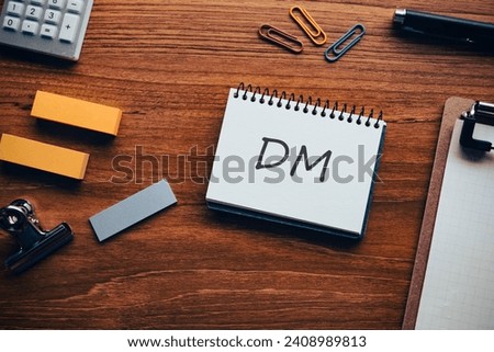 There is notebook with the word DM. It is an abbreviation for Direct message as eye-catching image. Royalty-Free Stock Photo #2408989813