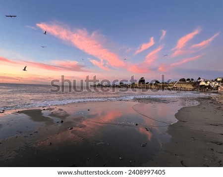 Sunrise in Capitola Village wispy pink clouds over the beautiful Monterey Bay. ￼ Royalty-Free Stock Photo #2408997405