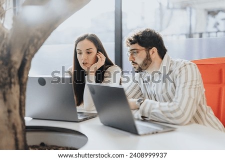 Diverse coworkers collaborating, discussing project details, analyzing market research, and sharing ideas in an office. Teamwork contributing to business success. Royalty-Free Stock Photo #2408999937