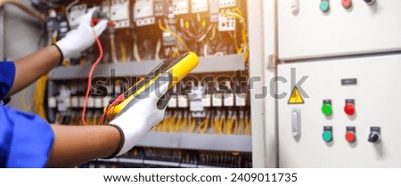 Electricity and electrical maintenance service. Engineer hand checking electric current voltage at circuit breaker terminal and cable wiring in main power distribution board AHU starter control panel. Royalty-Free Stock Photo #2409011735