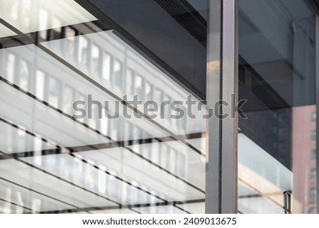 Glass window reflecting modern office buildings. Abstract architectural background.
