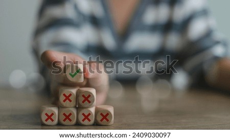 Hand putting wooden cube with tick checkmark right icon over the cross wrong icons. Finding the correct way after making many mistakes. Royalty-Free Stock Photo #2409030097