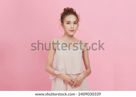 Asian woman with a beautiful face and fresh, smooth skin is dressed in pink. 