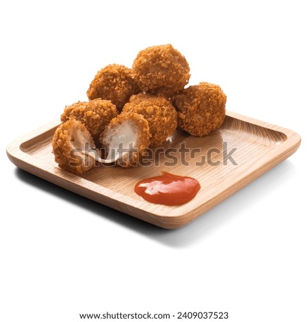 Crispy golden fried cheese balls served on a wooden plate with a side of ketchup, perfect for stock photography              