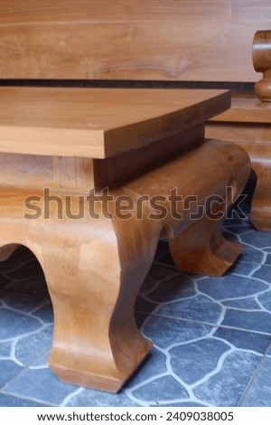 Wooden chairs and countertops, in the living room wooden table and chairs, made of teak wood, the main material, looks strong and sturdy, wood color, fine carvings, large and minimalist shape, strong 