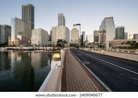 Brickell Key Bridge and City of Miami skyline at sunrise under clear blue sky on tranquil December morning.