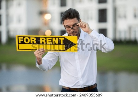a man in a white shirt holding money in his hands. real state agent giving new house key. Estate agent with customer before contract signature. male real state agent with a for sale or rent sign.