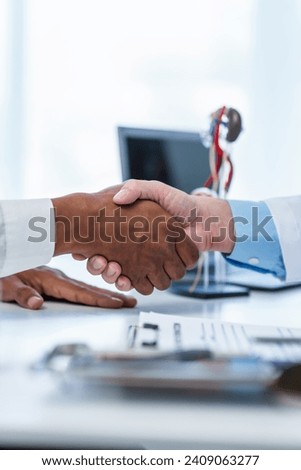 close-up handshake between two individuals, doctor and other casual shirt. doctor-patient relationship, agreement on treatment plan,  conclusion of medical consultation. Royalty-Free Stock Photo #2409063277