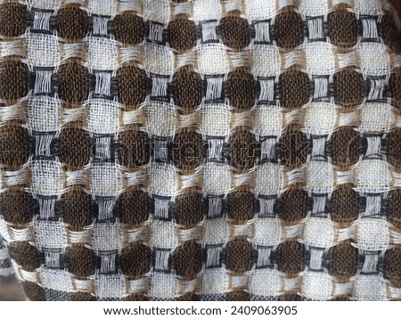 Abstract and fabric textures include brown, cream and black checkered motifs, with large and small square patterns. Fashion and style. Selected focus.
