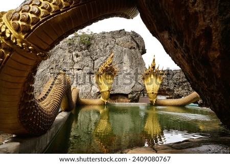 Golden serpent named Muthalin at Wat Phu Taphao Thong It is beautiful and sacred, with many tourists coming to pay their respects, Udon Thani, Thailand.