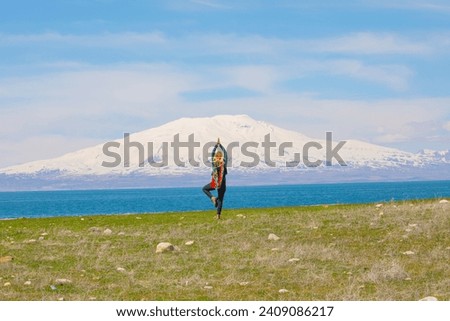 A woman across Mount Ararat walks and does gymnastics