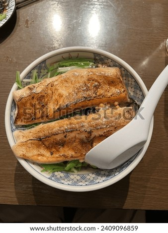 it looks like tuna fish that is grilled briefly, then served with rice, broth, and chopped spring onions. I got this at a Japanese restaurant Royalty-Free Stock Photo #2409096859
