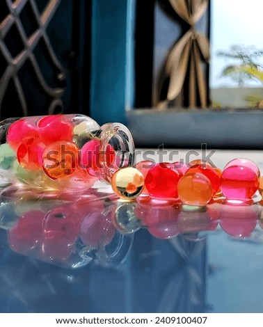A glass jar filled with colorful marbles
A group of round objects with faces on them
A glass jar with colorful balls in it