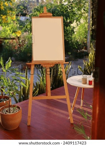 Easel with blank paper and drawing tools on the balcony home.