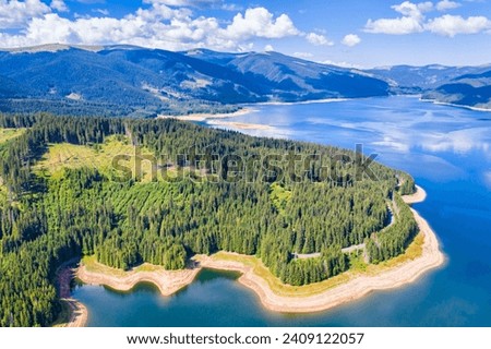 Vidra Lake is situated in the Parâng Mountains, part of the Southern Carpathians. The lake is situated at a high altitude, contributing to its scenic alpine setting. Royalty-Free Stock Photo #2409122057