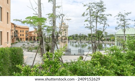 Photo of the location: a river, a wide pond surrounded by a black fence in the middle of a tall building, a European style house. The atmosphere is quiet. It's like a foreign country, paved with stone